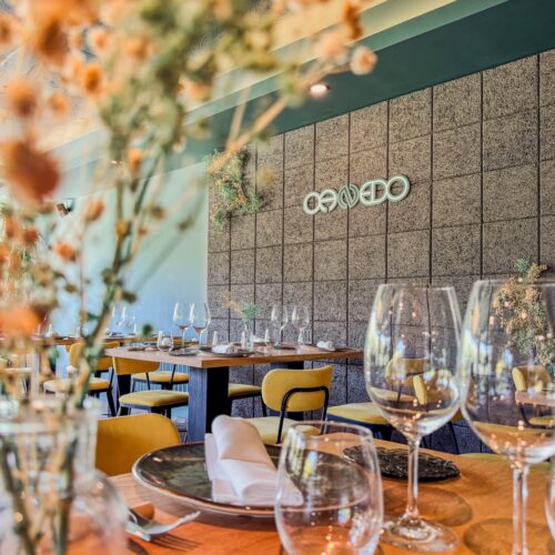 Comedor de Canedo con copas en primer plano y el logotipo en la pared