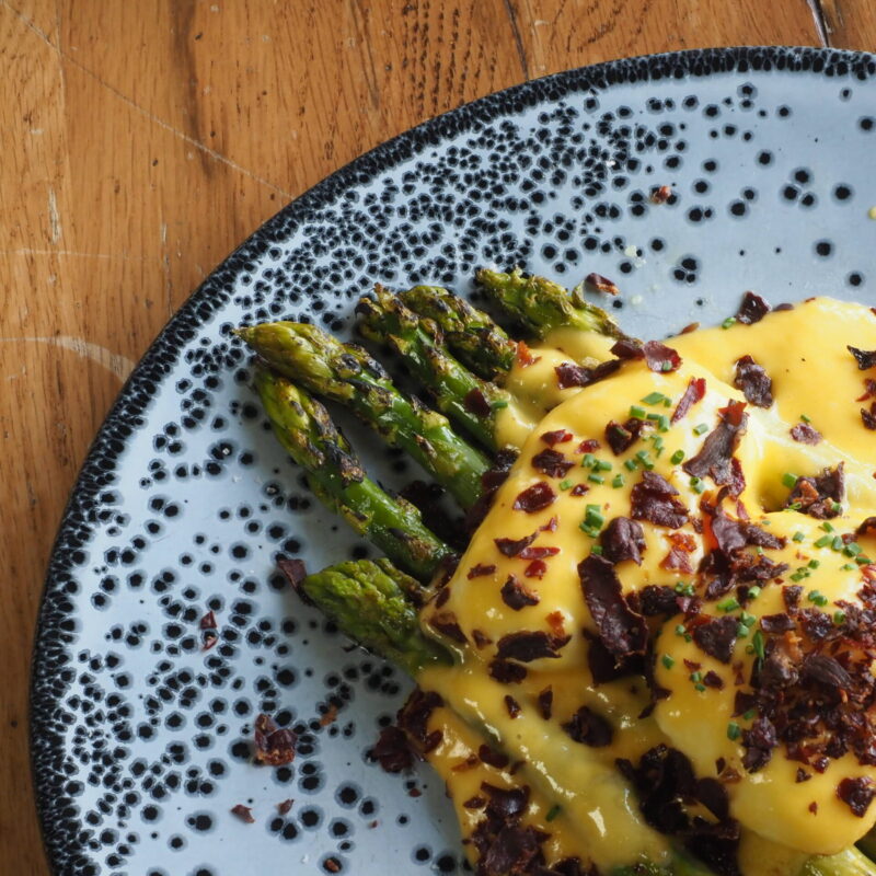 Espárragos trigueros a la brasa con salsa holandesa, huevo poché y jamón crujiente