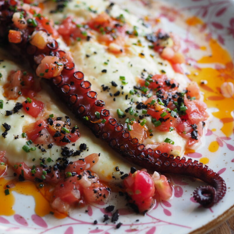 Tentáculo de pulpo a la brasa con salsa vierge, polvo de aceituna negra y parmentier