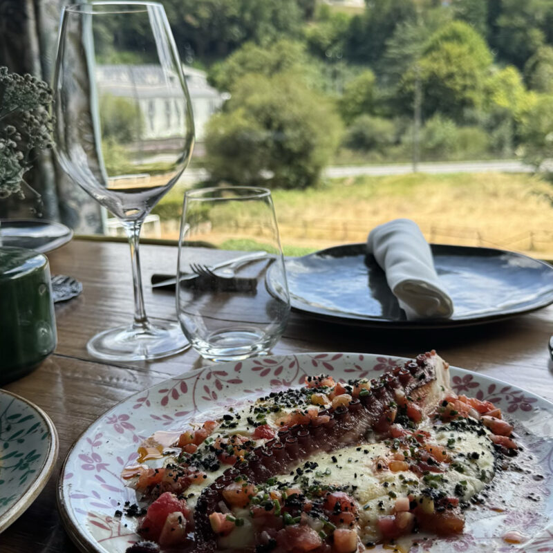 Pulpo a la brasa con parmentier en una mesa de Canedo con vistas al río