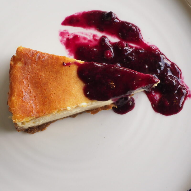 Tarta de queso cremosa casera con coulis de frutos del bosque