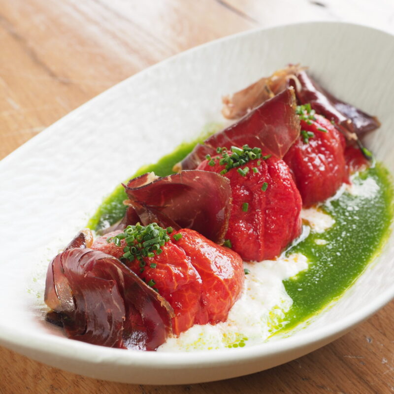 Tomates semisecos con cecina premium, stracciatella y aceite de romero